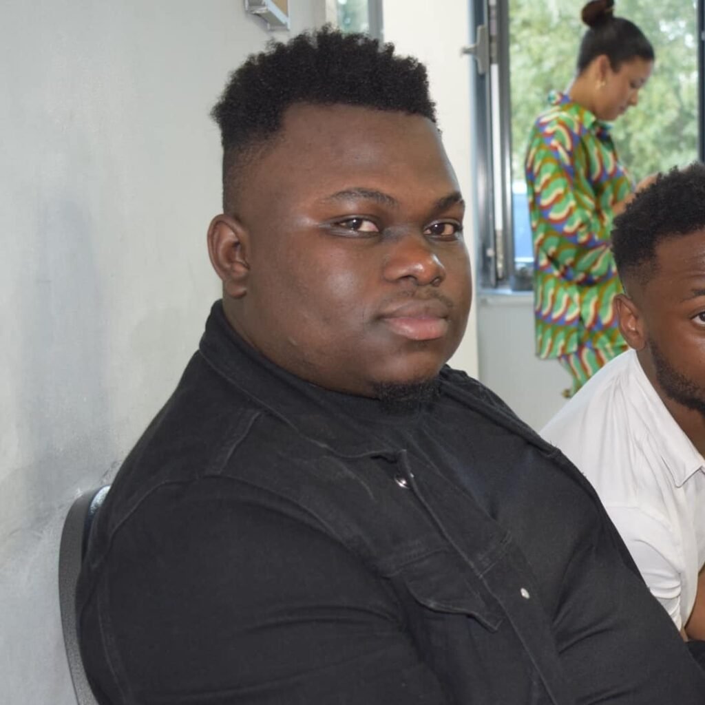 Alex Kimwesa sitting and looking directly at the camera, confident and composed