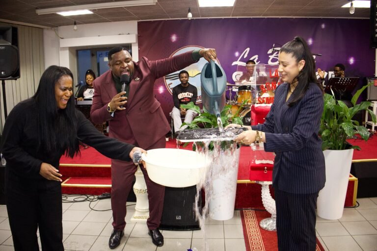 A lively celebration scene with water pouring from a watering can into a large bowl during an event.