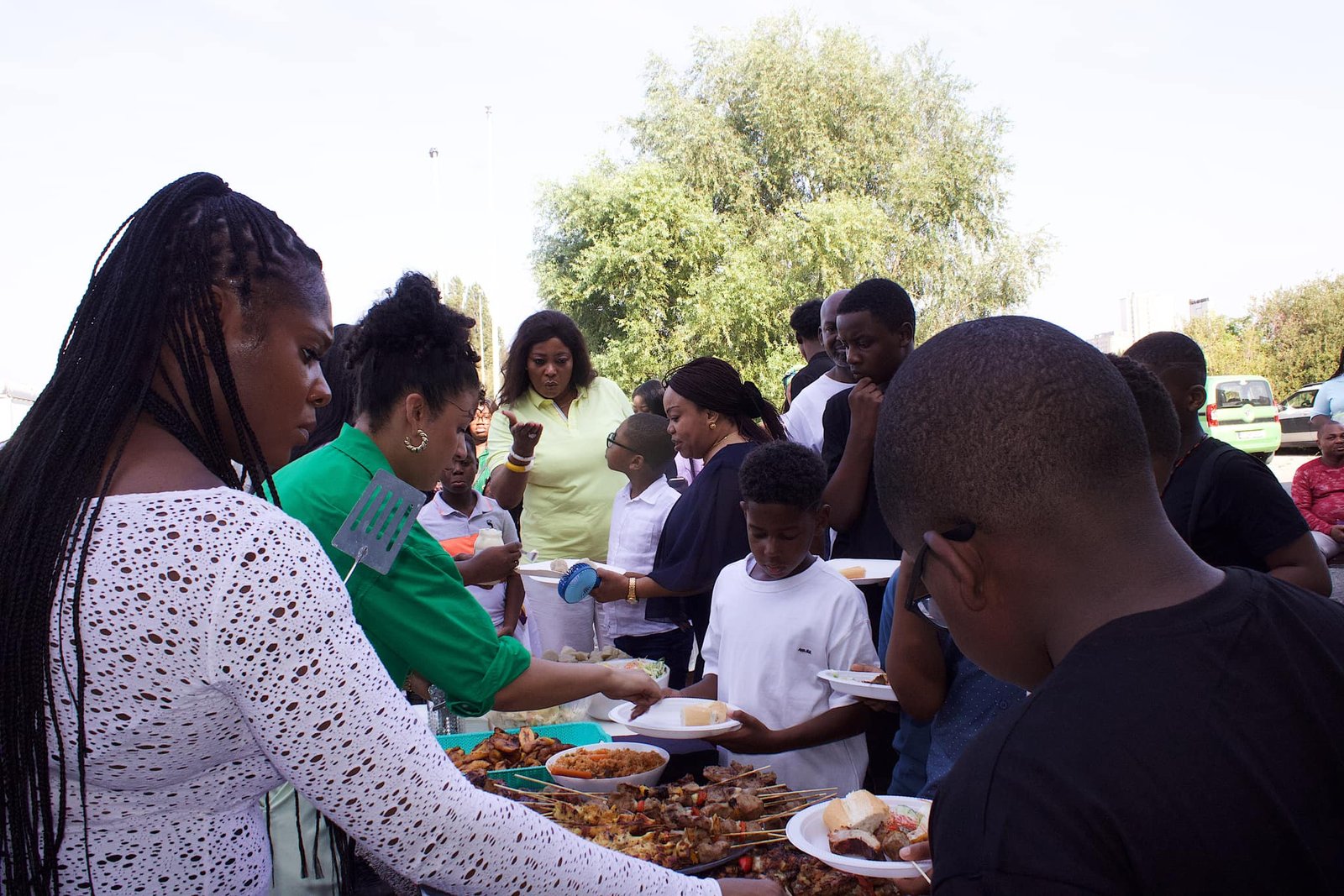 Church community members serving and enjoying food outdoors at a church event